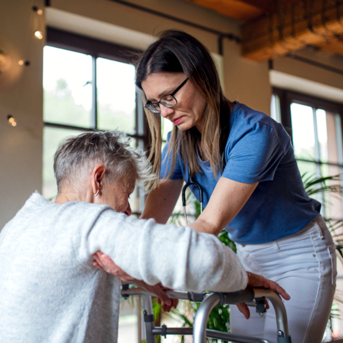 Pflegekraft hilft Mann aufstehen iStock Halfpoint.jpg
